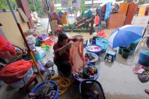 Norzawati Ibrahim, 41, membasuh pakaian ketika membersihkan rumahnya yang ditenggelami air akibat banjir