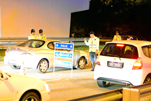 PETUGAS Jabatan Siasatan dan Kawalan Lalu Lintas (JSKLL), Pasukan Polis Diraja Brunei (PDB) Daerah Brunei dan Muara  membuat pemeriksaan dalam sekatan jalan raya. (Foto : Muhammad Asri Haji Awang Abas)