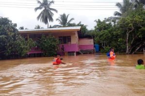 Anggota Bomba dan Penyelamat memindahkan mangsa banjir setelah Kampung Rugading mula dinaiki air di Tawau, Jumaat. Foto BERNAMA